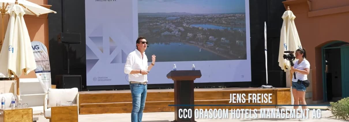 Ein Mann hält einen Vortrag bei einer Veranstaltung im Freien.